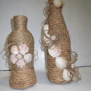 2 jute wrapped shell decorated wine bottles/vase.
